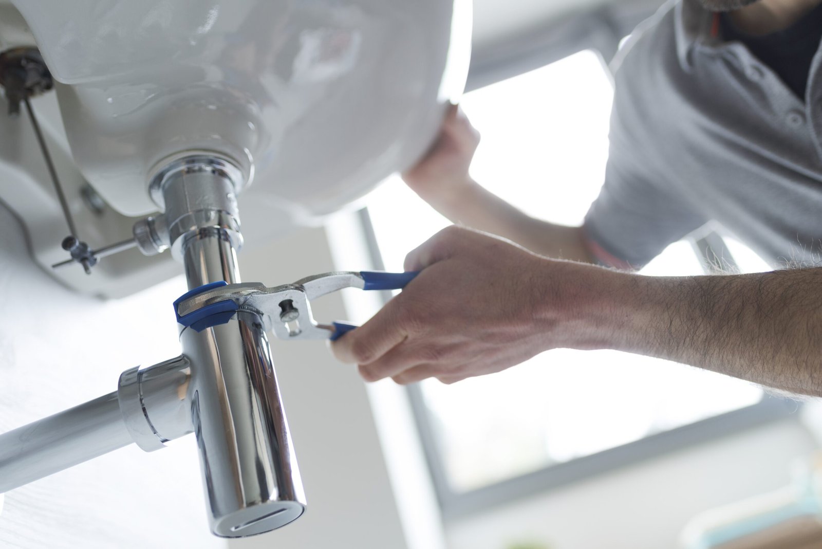 Professional,Plumber,Fixing,A,Leaking,Bathroom,Sink,,He,Is,Using